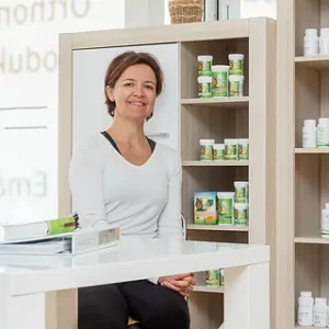 Frau sitzt lächelnd in einem Praxisraum