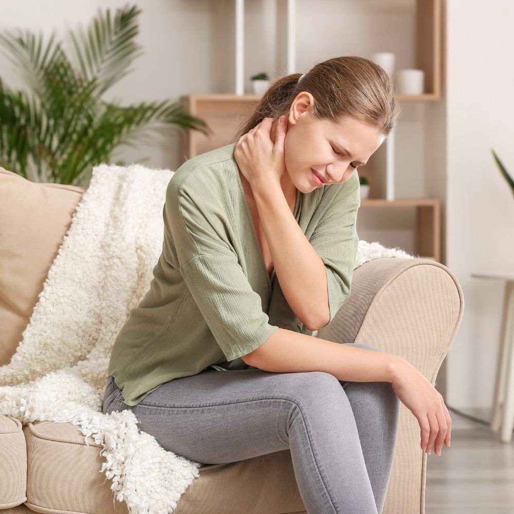 Frau hält sich am Nacken – Rückenschmerzen