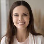 Portrait einer lächelnden Frau vor hellem Hintergrund