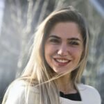 Portrait einer lächelnden jungen Frau im Freien